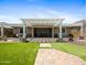 Beautiful backyard with artificial turf, pavers, mature trees, and a covered patio area at 30287 N 115Th Dr, Peoria, AZ 85383