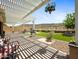 Backyard featuring a pergola, gravel, artificial grass, and outdoor seating with desert views at 30287 N 115Th Dr, Peoria, AZ 85383