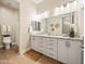 Bright bathroom featuring dual sinks with granite countertops and modern lighting fixtures at 30287 N 115Th Dr, Peoria, AZ 85383