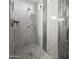 Updated bathroom with a tiled shower, marble floor, and chrome shower head at 30287 N 115Th Dr, Peoria, AZ 85383