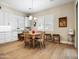 Eat-in kitchen breakfast nook area with wooden table and chairs and white cabinets in a light and airy design at 30287 N 115Th Dr, Peoria, AZ 85383