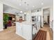 Bright kitchen with white cabinetry, a center island with granite countertops, stainless appliances, and open to the living space at 30287 N 115Th Dr, Peoria, AZ 85383
