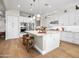 Bright kitchen with an island, pendant lights, stainless appliances, and white cabinets at 30287 N 115Th Dr, Peoria, AZ 85383