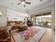 Cozy living area with plush leather seating, decorative rug, and seamless access to the kitchen and outdoor patio at 30287 N 115Th Dr, Peoria, AZ 85383