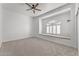 Spacious bedroom features a window nook with seating, a ceiling fan, and neutral carpet at 31234 N 47Th Pl, Cave Creek, AZ 85331