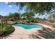 A desert home's refreshing pool with natural rock landscaping and mature trees at 31234 N 47Th Pl, Cave Creek, AZ 85331