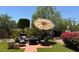 Outdoor patio area with an umbrella-covered table and chairs, plus beautiful plants and brick pavers at 3201 E Colter St, Phoenix, AZ 85018