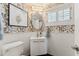 Stylish powder room featuring patterned wallpaper, white vanity, and subway tile wainscoting at 3201 E Colter St, Phoenix, AZ 85018
