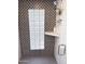 Modern walk-in shower with glass block window and decorative black and grey tiling at 3201 E Colter St, Phoenix, AZ 85018