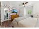 Bright bedroom featuring modern ceiling fan, TV, designer wallpaper, and hardwood floors at 3201 E Colter St, Phoenix, AZ 85018