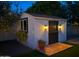 A well-lit shed with black trim complements the backyard with a tile entrance, window box, and potted plant at 3201 E Colter St, Phoenix, AZ 85018