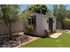 Backyard shed complete with artificial grass, window, and pot for plants at 3201 E Colter St, Phoenix, AZ 85018