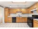 Spacious kitchen featuring tile floors, wooden cabinets, and black appliances at 3649 E Delcoa Dr, Phoenix, AZ 85032