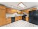 Functional kitchen with tile flooring, wooden cabinets, and black appliances, perfect for culinary enthusiasts at 3649 E Delcoa Dr, Phoenix, AZ 85032