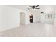 Open living room with tile floors, arched doorway, ceiling fans and access to other rooms at 3649 E Delcoa Dr, Phoenix, AZ 85032