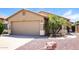 Home exterior featuring a two-car garage, desert landscaping, and tan stucco at 3750 S Conestoga Rd, Apache Junction, AZ 85119