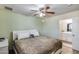 Comfortable bedroom features a ceiling fan and an en-suite bathroom at 3807 N 56Th Dr, Phoenix, AZ 85031