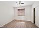 Bedroom features a ceiling fan, wood-look floors, and a window with wood blinds at 3850 E Geronimo St, Gilbert, AZ 85295