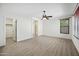 Spacious bedroom features a ceiling fan, wood-look floors, and a view to the ensuite bathroom at 3850 E Geronimo St, Gilbert, AZ 85295