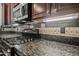 Close-up of kitchen featuring gas range, tiled backsplash, and granite countertops at 3850 E Geronimo St, Gilbert, AZ 85295