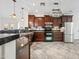 Well-lit kitchen featuring stainless steel appliances, granite countertops, and wooden cabinets at 3850 E Geronimo St, Gilbert, AZ 85295
