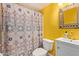 Bathroom with bright yellow walls features a modern vanity and patterned shower curtain at 4331 E Redwood Ln, Phoenix, AZ 85048