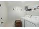 Functional laundry room with white washer, dryer, and storage solutions at 4331 E Redwood Ln, Phoenix, AZ 85048