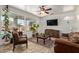Comfortable living room featuring large windows, leather sofa, and decorative plants at 4331 E Redwood Ln, Phoenix, AZ 85048