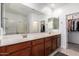 Bright bathroom featuring a double vanity, large mirror and a walk-in closet for convenient storage at 4562 S Park Grove St # 101, Gilbert, AZ 85297