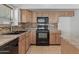 This classic kitchen offers wood cabinetry, tile backsplash, and modern black appliances at 4566 E La Costa Dr, Chandler, AZ 85249