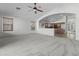 Large carpeted living room with ceiling fan and partial kitchen view at 4566 E La Costa Dr, Chandler, AZ 85249