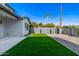 A view of the backyard that features green grass, decorative rock, a patio, and a block wall for added privacy at 4813 E Earll Dr, Phoenix, AZ 85018