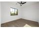 Bright bedroom with modern ceiling fan, expansive window, and hardwood flooring at 4813 E Earll Dr, Phoenix, AZ 85018