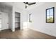 Bright bedroom featuring hardwood floors, white walls, modern ceiling fan, and natural light from black-trimmed windows at 4813 E Earll Dr, Phoenix, AZ 85018
