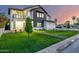 A modern home featuring a green lawn with a pathway and tasteful landscaping at dusk at 4813 E Earll Dr, Phoenix, AZ 85018