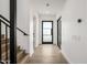 Bright hallway featuring light wood floors, white walls, and a contemporary black-framed glass door at 4813 E Earll Dr, Phoenix, AZ 85018