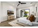 Comfortable main bedroom with a media center, access to the back yard, and a plush bed at 4813 E Earll Dr, Phoenix, AZ 85018