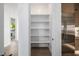 Walk-in pantry with shelving, stainless steel refrigerator and wood floor at 4813 E Earll Dr, Phoenix, AZ 85018