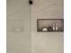 Modern shower featuring large neutral tile, a convenient recessed shelf, and sleek glass partition at 4813 E Earll Dr, Phoenix, AZ 85018