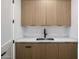 A utility sink is set in custom natural wood cabinetry with a marble-look countertop at 4813 E Earll Dr, Phoenix, AZ 85018