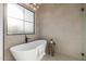 A soaking tub is accompanied by a modern faucet and fixtures near a large window at 4813 E Earll Dr, Phoenix, AZ 85018
