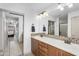 Bright bathroom featuring double sinks, wood cabinets, mosaic backsplash, and a shower with a glass door at 5350 E Deer Valley Dr # 1419, Phoenix, AZ 85054