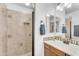 A bathroom featuring a tile shower, sink with cabinets, and decorative backsplash at 5350 E Deer Valley Dr # 1419, Phoenix, AZ 85054