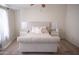 Serene bedroom with a tufted headboard bed, neutral decor, and soft carpet flooring at 5515 E Elena Ave, Mesa, AZ 85206