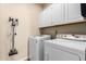 Well-equipped laundry room with washer, dryer, cabinets, and convenient vacuum storage at 5731 W Gail Dr, Chandler, AZ 85226