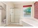 Bright bathroom featuring a soaking tub, shower, and large window at 5731 W Gail Dr, Chandler, AZ 85226