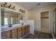 Bathroom featuring double sinks, mirrored wall, and a shower with glass door at 6101 E Beck Ln, Scottsdale, AZ 85254