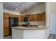 Functional kitchen with wooden cabinetry, a breakfast bar, and modern appliances at 6101 E Beck Ln, Scottsdale, AZ 85254