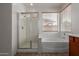 Bright bathroom featuring a glass shower and soaking tub near a window at 7205 W Ellis St, Laveen, AZ 85339