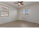 Bright, minimalist bedroom featuring a ceiling fan and dual windows at 7205 W Ellis St, Laveen, AZ 85339